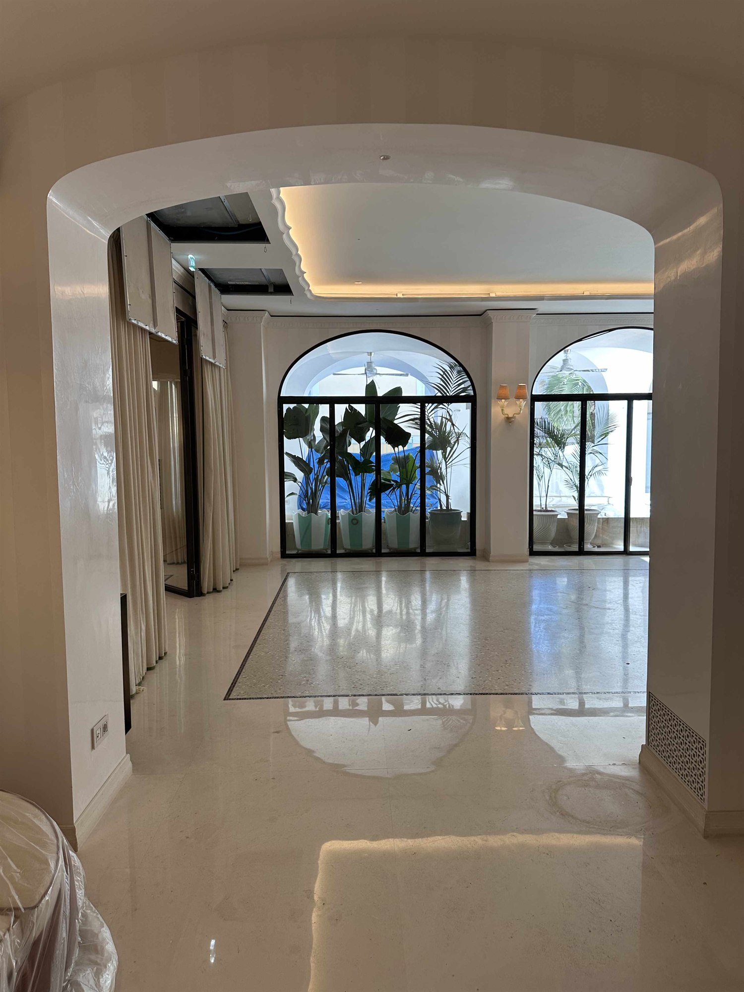 Foto della sala voltata reale con serramenti ad arco a telaio nero e piante in vaso verso la terrazza